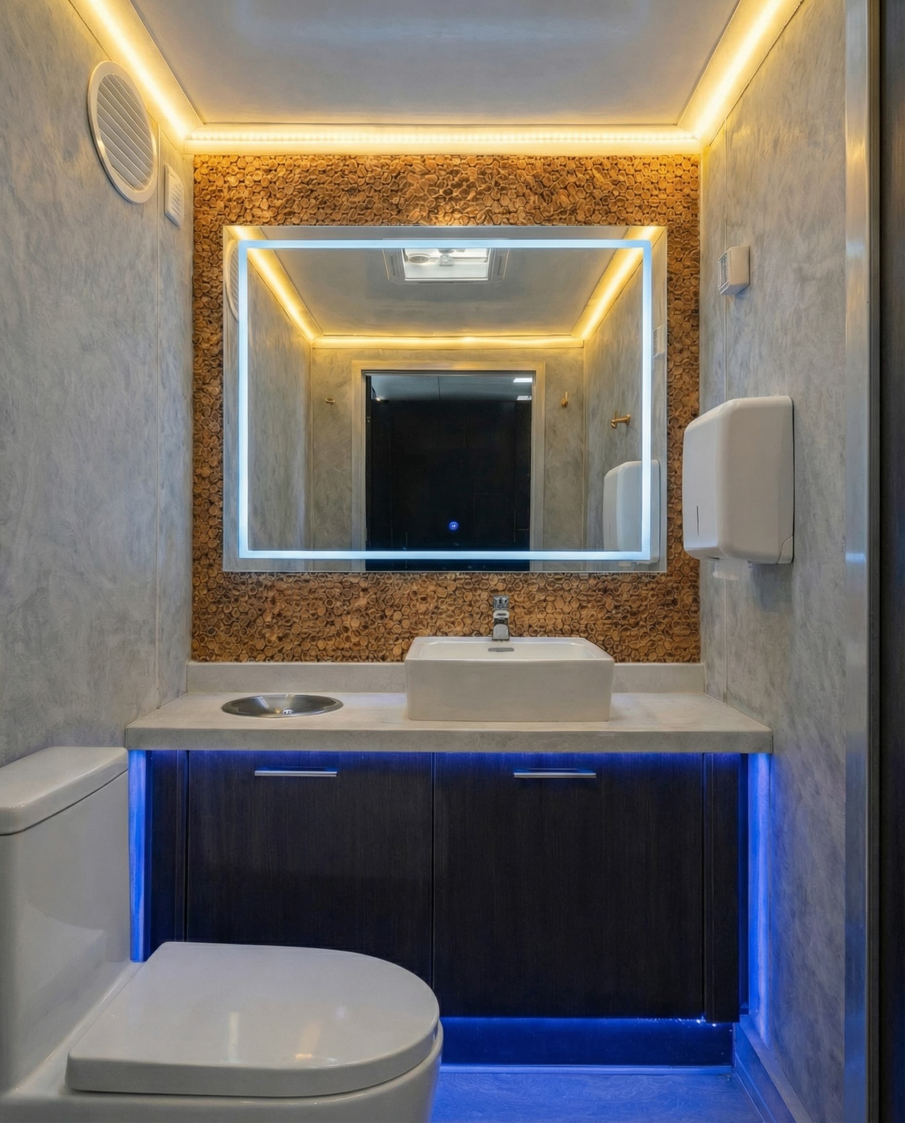 Modern bathroom with vessel sink, backlit mirror, blue LED accents, and warm ceiling lighting.